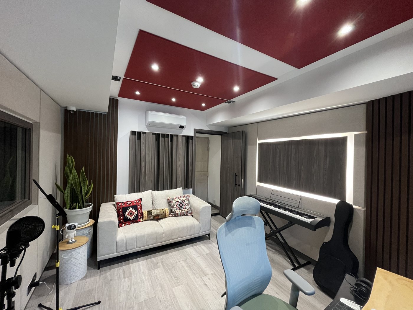 Sala principal del estudio con sofá, teclado y micrófonos
